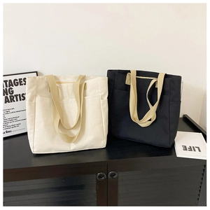 Vue détaillée de grands sacs fourre-tout en toile avec poignées tissées et poches