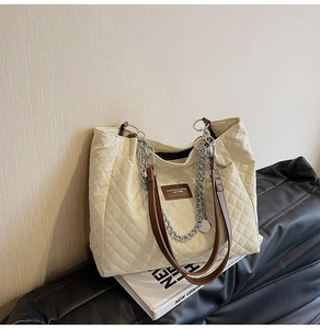 Sac cabas beige matelassé chic avec anses en cuir marron et détail chaîne argentée