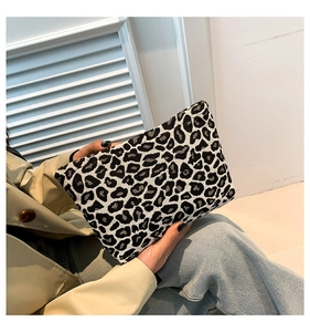 Fashion leopard print rectangular clutch bag held by model in casual chic attire