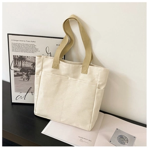 Détail du sac cabas en toile montrant les grandes poches et la texture du tissu épais