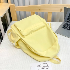 Vista dettagliata di uno zaino minimalista giallo pallido con ampie tasche e coulisse laterali