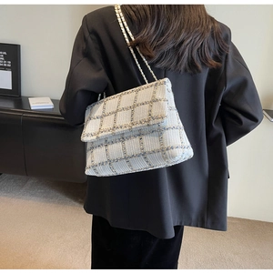 Sac bandoulière en tweed à carreaux bleus avec bandoulière chaîne sur un modèle