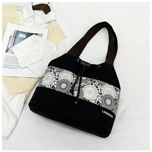 Detail of canvas bucket bag with floral lace print and brown drawstring closure