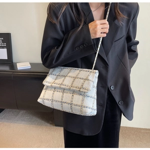 Détail du sac bandoulière en tweed à carreaux bleu et doré avec bandoulière chaîne