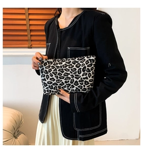 Close-up of leopard pattern canvas pouch held by model showing texture and size