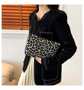Detail view of the leopard print clutch bag paired with a stylish casual outfit