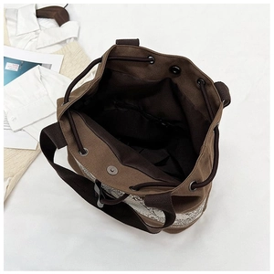 Deep brown canvas bucket bag showing drawstring closure and spacious interior compartment