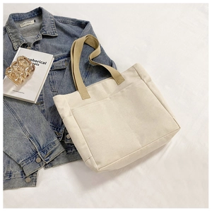 Détail du sac cabas minimaliste en toile beige avec poignées kaki et grande poche