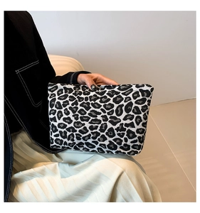 Close-up of minimalist leopard print fabric clutch bag showing fine knitted texture
