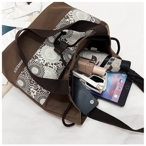 Detail of spacious canvas tote interior showing umbrella, phone and tablet storage