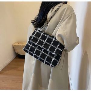 Sac à épaule en tweed à carreaux avec bandoulière chaîne porté par un mannequin