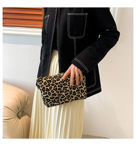 Detail of leopard print clutch bag showing soft plush texture and sleek zipper closure
