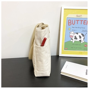 Détail de la poche latérale du sac en toile avec un rouge à lèvres pour le rangement