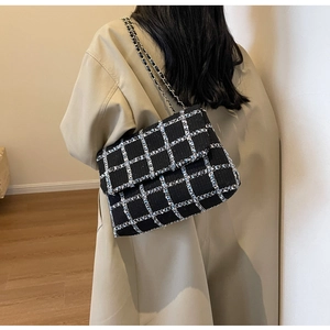 Gros plan d'un sac à bandoulière en laine à carreaux avec chaîne argentée sur modèle