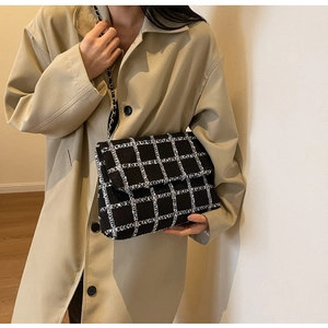 Détail du sac à bandoulière en tweed à carreaux noir et blanc avec chaîne en métal tressé