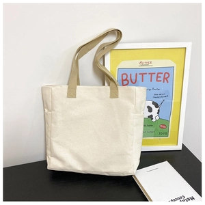 Détail du sac fourre-tout minimaliste en toile avec poche latérale et poignées en kaki