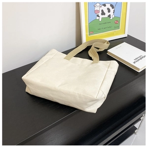 Détail du sac fourre-tout en toile beige minimaliste avec larges poignées kaki en tissu
