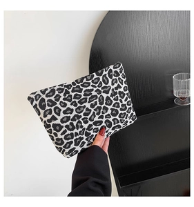 Close-up of a minimalist leopard print clutch bag with thick woven canvas texture