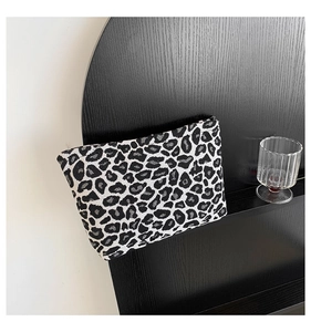 Detail of minimalist black and white leopard print clutch with textured jacquard fabric