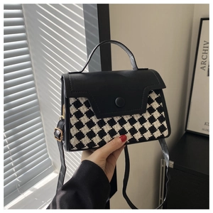 Detailsicht der Umhängetasche aus schwarzem Leder und monochromem Steppmuster mit Griff
