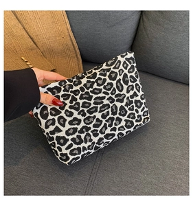 Detailed view of leopard print clutch showing durable fabric texture and sleek zipper