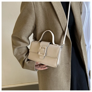 Détail d'un sac à main beige en similicuir avec boucle carrée et bandoulière réglable
