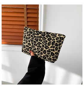 Close-up of leopard print canvas clutch bag with zipper closure and textured fabric