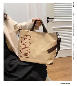 Large beige canvas tote bag with brown FASHION lettering and adjustable shoulder strap