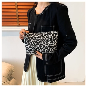 Minimalist leopard print pouch with zipper closure, shown in a trendy lifestyle setting