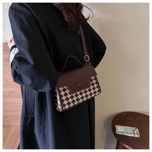 Detail der Retro-Hahnentritt-Struktur und der braunen Lederklappe an der kleinen Tasche