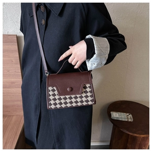 Detail der Vintage-Umhängetasche mit Hahnentrittmuster und Leder-Tragegriff oben