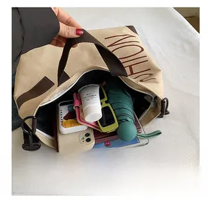 Detailed interior view showing large capacity for iPad and umbrella in beige canvas tote