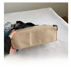 Close-up of durable wear-resistant bottom with reinforced leather corners on canvas tote bag