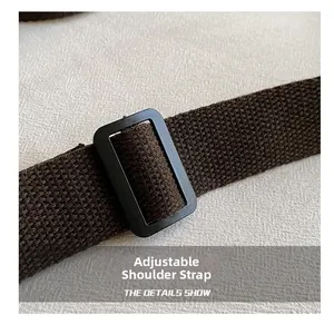 Detail of adjustable dark brown canvas strap with black buckle for versatile tote bags