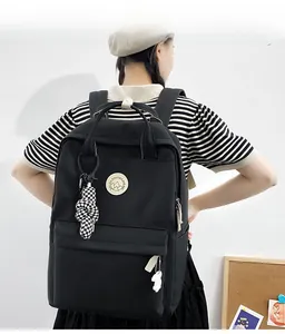 Rear view of a black minimalist backpack with cute dog and checkerboard pendants