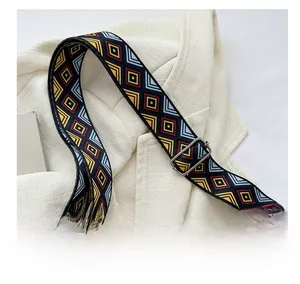 Detail of colorful geometric diamond pattern woven wide shoulder strap with metal buckle