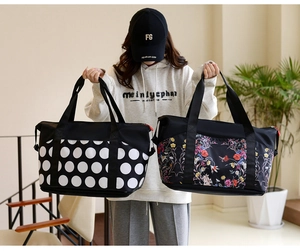 Close-up of large travel bags with polka dot and floral prints for yoga and gym