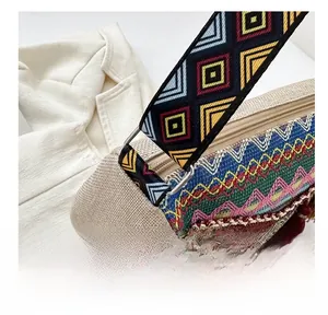 Detail of bohemian bag showing metal connector, colorful woven strap, and tassel charms