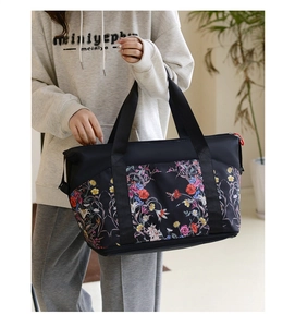 Close-up of the large travel bag showing colorful floral print on waterproof black fabric