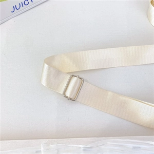 Detail view of the adjustable cream-colored nylon shoulder strap with a silver metal buckle