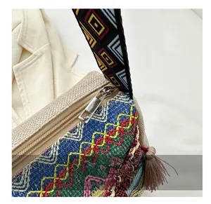 Close-up of smooth silver zipper and ethnic embroidery detail on bohemian crossbody bag