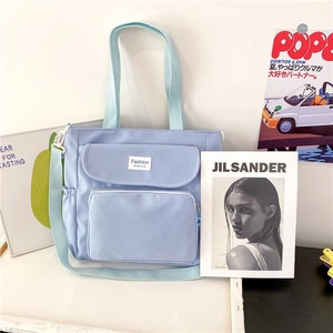 Detail of light blue nylon tote bag with dual handles and detachable wide shoulder strap