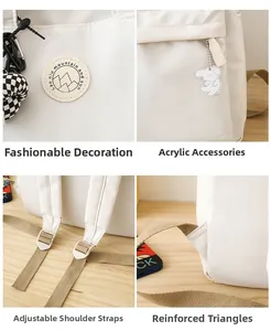 Detail of off-white backpack showing reinforced strap stitching and cute puppy pendant
