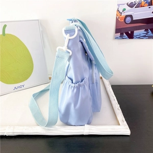 Detail of the side pocket with elastic drawstring on a blue canvas messenger bag