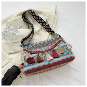 Detail of bohemian crossbody bag featuring colorful tassels and ethnic woven strap