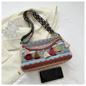 Detailed view of bohemian woven bag with colorful tassels and geometric ethnic patterns