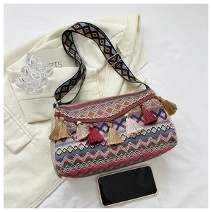 Close-up of bohemian shoulder bag with ethnic geometric patterns and colorful tassels