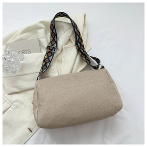 Detail of beige canvas shoulder bag with colorful ethnic geometric woven strap