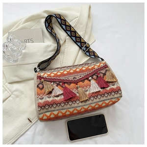 Detail of bohemian woven bag with colorful geometric patterns and long tassel fringe