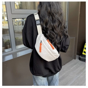 Back view of a person wearing a white sporty chest bag with orange zipper pull cords
